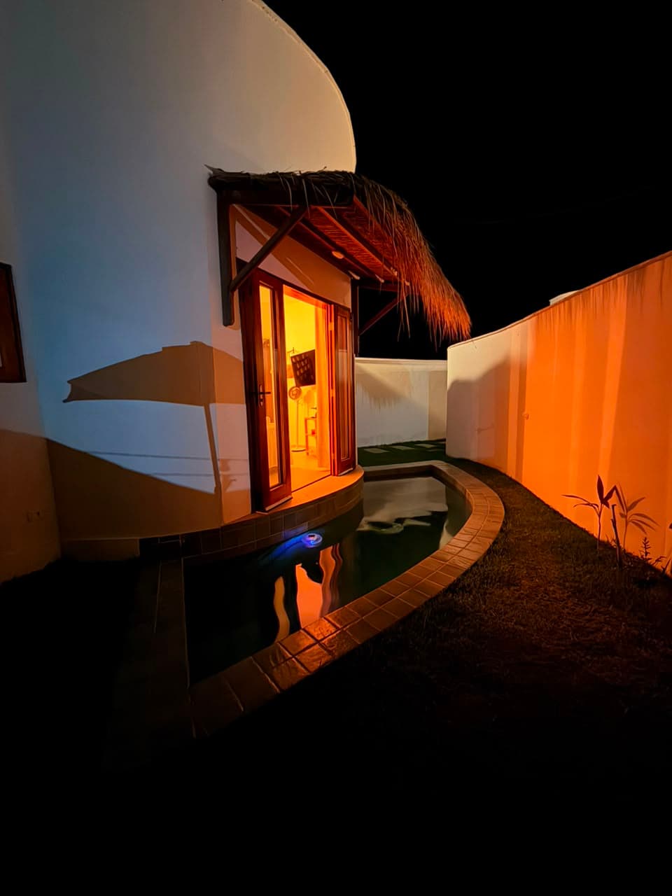 Piscina privativa iluminada ao anoitecer